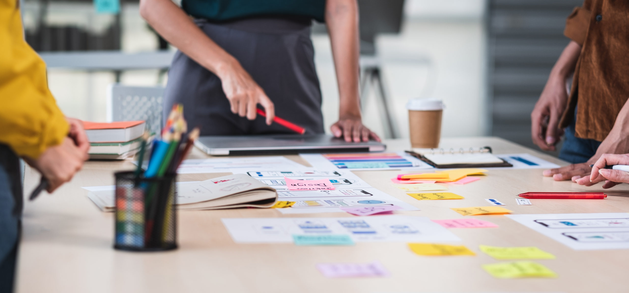 Close up ux developer and ui designer brainstorming about mobile app interface wireframe design on table with customer brief and color code at modern office.Creative digital development agency.panning